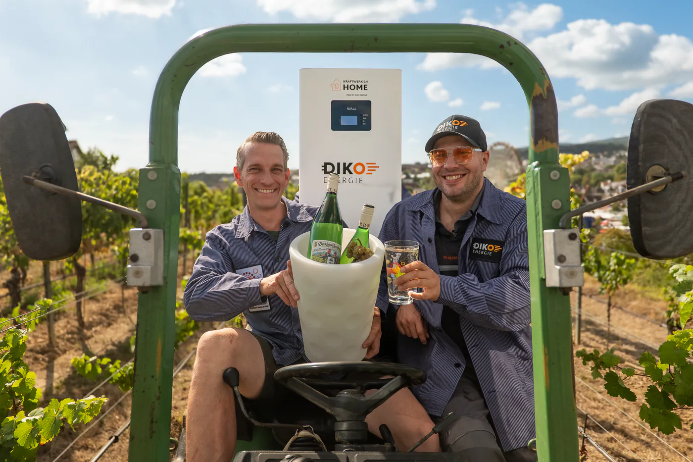 Zwei DIKO-Mitarbeiter auf dem Traktor im Weinberg mit dem Dubbeglas-Weinkühler und dem KRAFTWERK-14 HOME